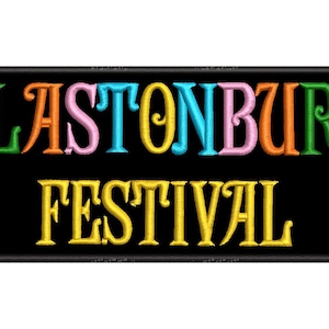 May include: A rectangular black embroidered patch featuring the text GLASTONBURY in multi-coloured letters including red, green, orange, pink, blue, and yellow. Below this, the word FESTIVAL is embroidered in solid yellow capital letters.