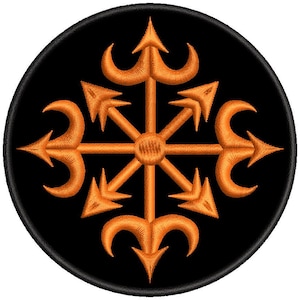 Könnte beinhalten: Ein kreisförmiger gestickter Aufnäher mit schwarzem Hintergrund und einem zentralen orangefarbenen Symbol. Das Design besteht aus einem Mittelkreis mit acht strahlenförmigen Armen, die zwischen geraden Pfeilen und gebogenen Hakenformen abwechseln.