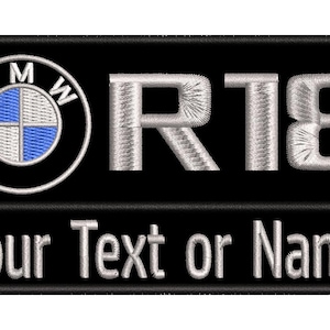 Può includere: Una toppa rettangolare nera ricamata con il logo BMW bianco e blu sulla sinistra, il testo R18 bianco argento al centro e la frase Your Text or Name ricamata in lettere bianche lungo la sezione inferiore della toppa.