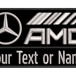 May include: A rectangular black embroidered patch featuring the silver Mercedes-Benz three-pointed star logo, the silver AMG logo with slanted bars, and the white text Your Text or Name stitched in a clean sans-serif font on the lower section.