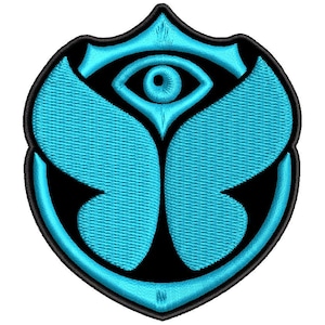 Op de afbeelding: Een schildvormige geborduurde patch met een felcyaan vlinderontwerp gecentreerd op een zwarte achtergrond. De bovenkant van het schild toont een enkel oogmotief en het hele embleem is omlijnd met een dikke zwarte rand.