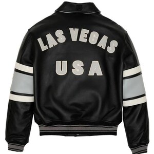 May include: Black leather jacket with the words "LAS VEGAS USA" in white and gray lettering on the back. The jacket has white and gray stripes on the sleeves and a gray and white striped hem and cuffs.