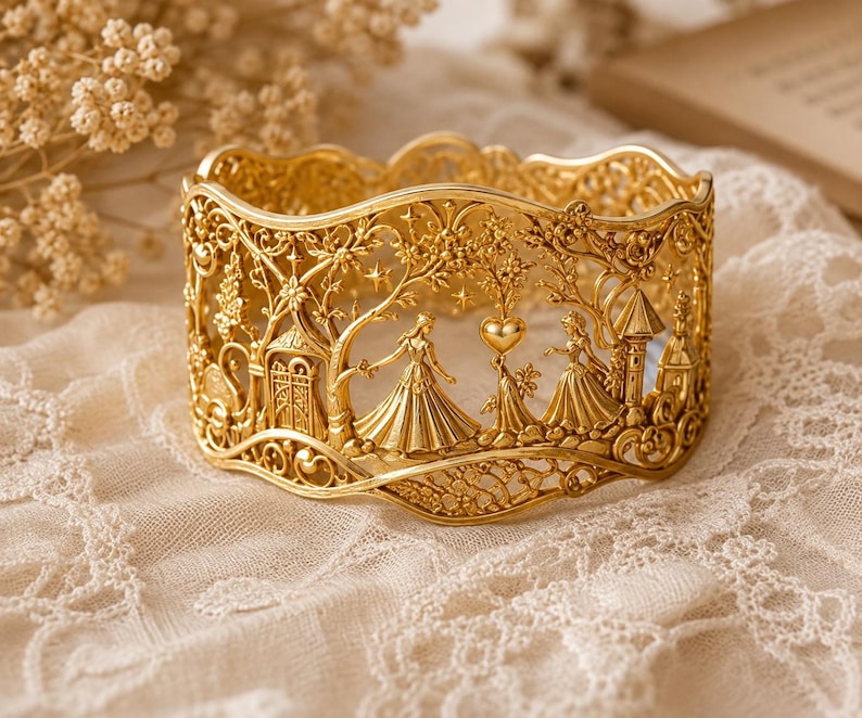 May include: A wide gold cuff bracelet featuring an intricate openwork design. The metal surface depicts two figures in gowns standing among trees, stars, a heart shape, and architectural structures with a scalloped top and bottom edge.