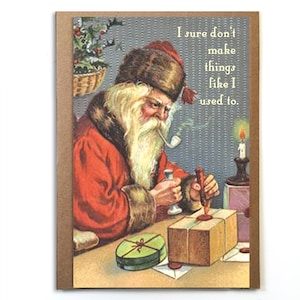 May include: A vintage Christmas card featuring a cartoon Santa Claus wearing a red suit and a fur-trimmed hat. He is sitting at a table with a candle and is sealing a package with wax. The text on the card reads "I sure don't make things like I used to."