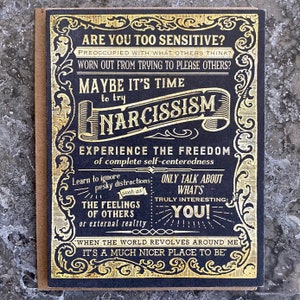 May include: A black and gold card with the text "Are you too sensitive?" and "Maybe it's time to try narcissism." The card features a decorative border and a vintage design.