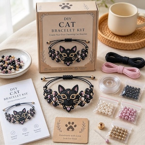 Könnte beinhalten: Ein DIY-Katzenarmband-Set mit einem Karton, der eine schwarze Katzengesicht-Illustration zeigt, einem fertigen schwarzen Makramee-Katzenarmband, einer Anleitung, Spulen mit schwarzer und rosa Kordel sowie kleinen Beuteln mit schwarzen, weißen und goldenen Perlen.