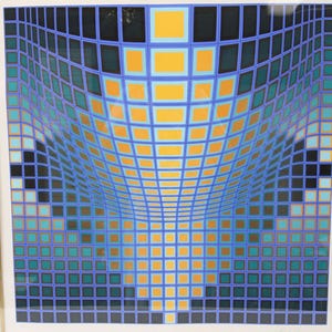 May include: Abstract geometric art print featuring a grid pattern with a curved perspective. The artwork uses a palette of blue, teal, orange, and black squares, creating a visual illusion of depth and movement. The print is framed in a white border.