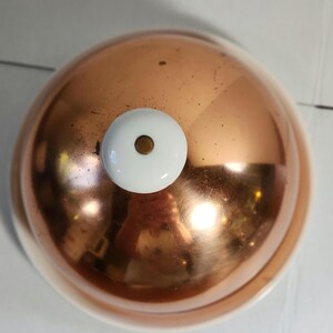 Vintage Kupferglocke mit Keramikteller. Weißer Knauf auf kupferner Kuppel. Ideal für die klassische Präsentation von Speisen.