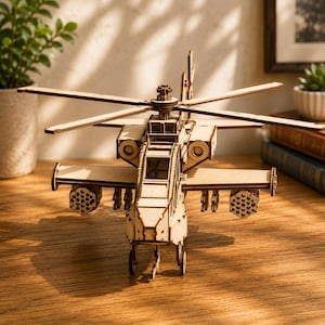 May include: A light-colored wooden model helicopter featuring a detailed cockpit, rotating main rotor blades, and side-mounted weapon pods. The structure is composed of interlocking laser-cut pieces, showcasing a natural wood grain finish throughout.