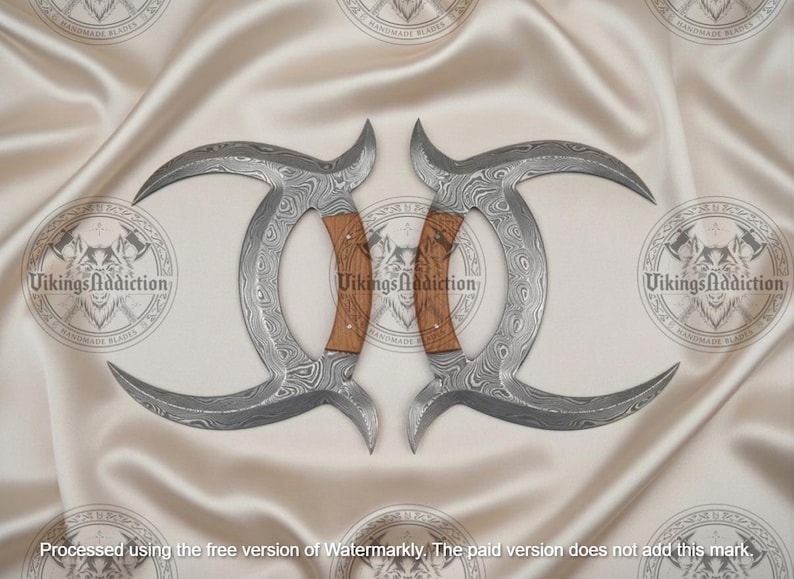 May include: Two curved, Damascus steel blades with wooden handles, arranged symmetrically. The blades have a unique pattern and are set against a cream-colored, textured background. The logo "VikingsAddiction" is visible.