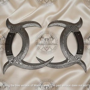 May include: Two curved, Damascus steel blades with dark wood handles. The blades have a unique pattern and are arranged symmetrically against a cream-colored background. The text "VikingsAddiction" is visible.