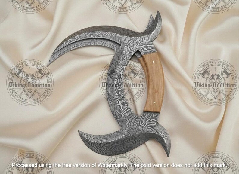 May include: A Damascus steel karambit knife with a curved blade and a wooden handle. The blade has a unique pattern, and the handle is light brown. The knife is displayed on a cream-colored fabric.
