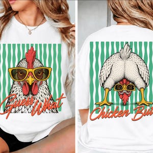 May include: A white t-shirt featuring a graphic of a chicken wearing yellow sunglasses. The front displays the chicken's face with the text "Guess What" in orange. The back shows the chicken bending over with the text "Chicken Butt" in orange.