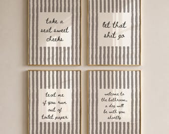 May include: A set of four rectangular wall art prints in thin gold frames. Each print features a white center with black cursive text surrounded by a gray and white vertical striped border. The text reads: take a seat sweet cheeks, let that shit go, text me if you run out of toilet paper, and welcome to the bathroom, a dog will be with you shortly.