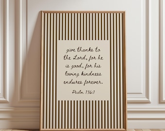 May include: A rectangular framed wall art piece featuring a vertical brown and cream striped pattern. In the center, a cream-colored rectangular block displays the black text: give thanks to the Lord, for he is good, for his loving kindness endures forever. Psalm 136:1.