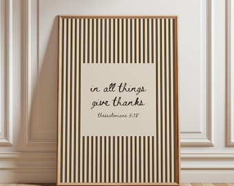 May include: A rectangular framed wall art piece featuring a vertical brown and cream striped pattern. A central cream-colored square contains the dark brown handwritten text: in all things give thanks thessalonians 5:18.