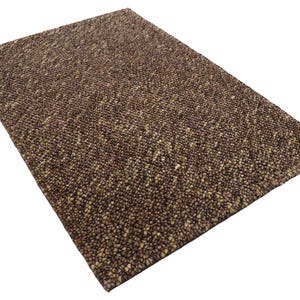 Peut inclure: Un tapis rectangulaire marron avec une surface texturée et mouchetée. La palette de couleurs du tapis comprend des nuances de marron, de beige et de beige clair, créant une esthétique neutre et terreuse. Idéal pour divers styles d'intérieur.