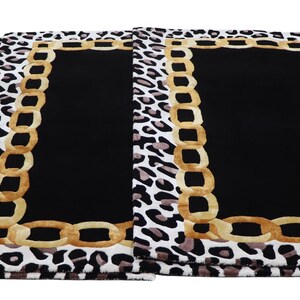 May include: Three rectangular placemats featuring a central solid black panel bordered by a gold-coloured chain link pattern. The outer edge of each placemat displays a white, black, and grey leopard print design on a rectangular fabric surface.