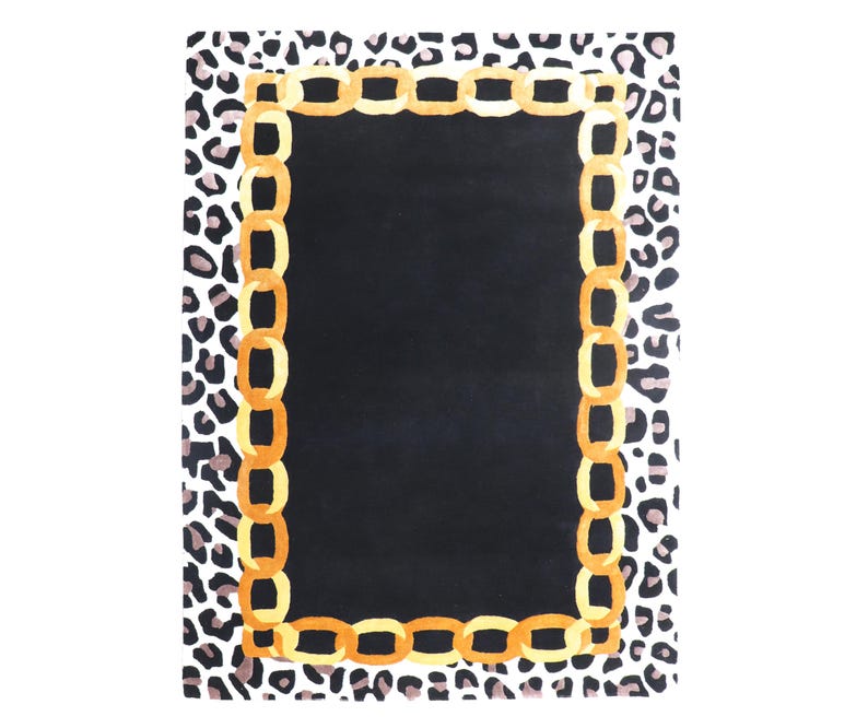 May include: A rectangular area rug featuring a solid black centre panel surrounded by a border of golden yellow interlocking chain links. The outer edge of the rug displays a repeating black and grey leopard print pattern on a white background.