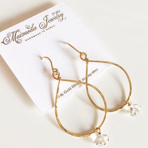 May include: Gold filled teardrop earrings with clear crystal accents. The earrings are handmade in Hawaii by Maimoda Jewelry.