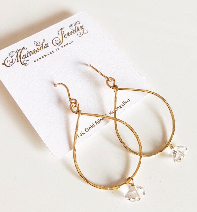 May include: Gold filled teardrop earrings with clear crystal accents. The earrings are handmade in Hawaii by Maimoda Jewelry.