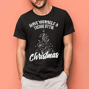 May include: A black short-sleeved t-shirt featuring a white graphic of a geometric Christmas tree made of nodes and lines. The text above the tree reads HAVE YOURSELF A TECHIE LITTLE and the word Christmas is printed in white script below.