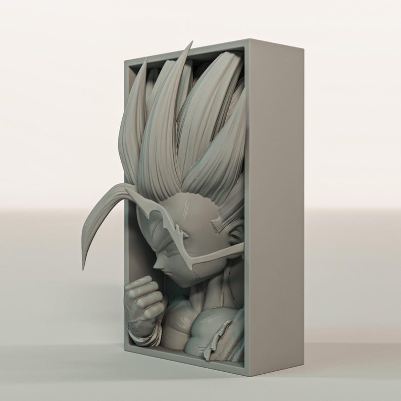 Puede incluir: Una escultura gris impresa en 3D de un personaje con pelo puntiagudo, dentro de un marco rectangular. La figura est&aacute; en una pose contemplativa, con el pu&ntilde;o cerrado y rasgos faciales detallados. Es un objeto de colecci&oacute;n.