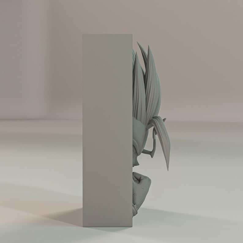 Puede incluir: Una escultura gris impresa en 3D de un personaje con pelo puntiagudo y una expresi&oacute;n decidida. La figura est&aacute; parcialmente oscurecida por un bloque rectangular, creando una composici&oacute;n visual &uacute;nica. La escultura es probablemente un objeto de colecci&oacute;n o decorativo.