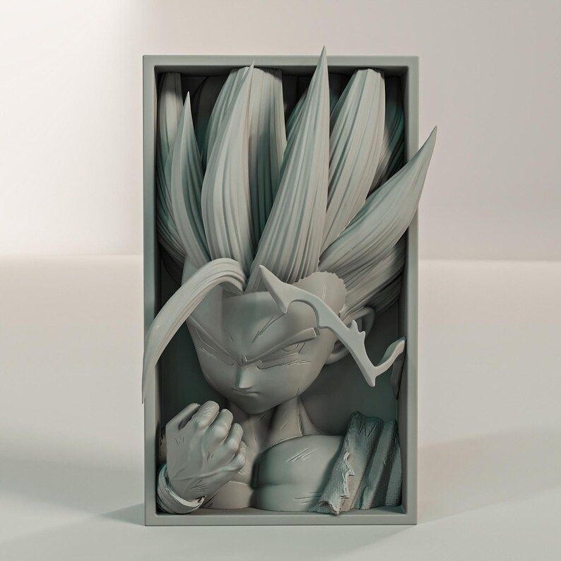 Puede incluir: Una escultura gris tridimensional de un personaje con cabello puntiagudo y una expresi&oacute;n decidida, enmarcada en un marco rectangular. El pu&ntilde;o de la figura est&aacute; cerrado y los detalles est&aacute;n finamente representados.