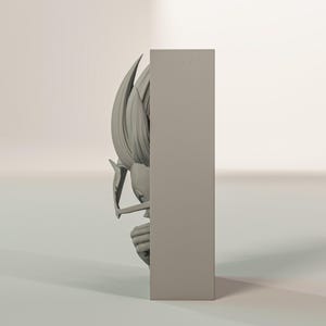 Puede incluir: Escultura gris tridimensional de un personaje con pelo puntiagudo y expresi&oacute;n decidida. La escultura es parcialmente visible, emergiendo de un bloque rectangular, lo que sugiere una obra de arte mural o un objeto decorativo.
