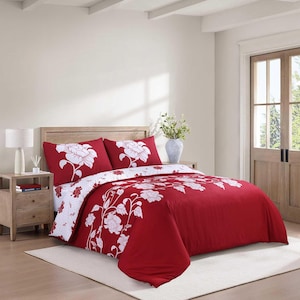 May include: A bedding set featuring a deep red duvet cover and two matching pillow shams, each adorned with a large white floral pattern. The bedding is displayed on a bed with a wooden headboard, complemented by a white bedside lamp.