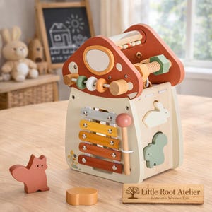 May include: Wooden mushroom-shaped toy with a xylophone, screw, and bead maze. Features a light wood base with colorful accents, including a red roof, yellow, orange, and brown xylophone keys, and a pink mallet. Includes a wooden squirrel and a small wooden block.