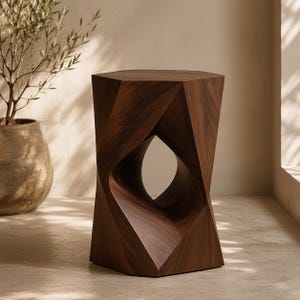 Puede incluir: Un taburete de madera marrón oscuro con un diseño geométrico facetado y una abertura central. El taburete tiene una superficie superior hexagonal y una estructura retorcida y angular que crea una silueta escultural con vetas visibles.