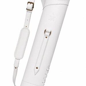 May include: A white archery quiver featuring an adjustable shoulder strap with a padded section, antique brass-toned metal hardware, and a decorative lace-up detail at the base. The quiver displays a small embossed logo of a bow and arrow.