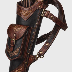 May include: A black and brown leather quiver featuring an attached storage pouch with a buckle closure. The quiver is decorated with embossed knotwork patterns and brass-colored metal rivets, and includes a matching adjustable leather shoulder strap.