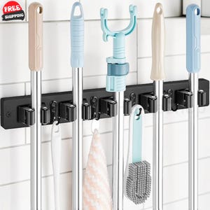 May include: A black wall-mounted organizer rack featuring multiple spring-loaded slots and hooks. The rack holds various cleaning tools with long handles, including mops and brushes with beige and light blue accents, plus a hanging cloth.