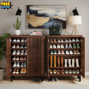 May include: Two dark brown wooden shoe storage cabinets with multiple shelves, filled with various shoes. The cabinets are open, revealing the contents. A green handbag and a lamp sit on top. A painting hangs on the wall.