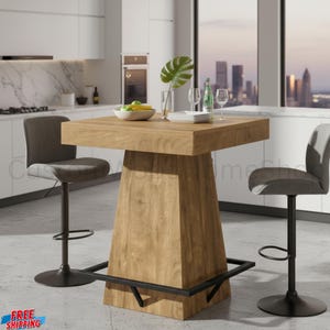 May include: A square wooden bar table with a thick top and a tapered pedestal base featuring a black metal footrest. Two gray upholstered bar stools with black metal stems and circular bases are positioned on opposite sides of the table.