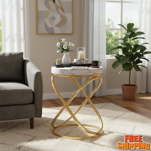 May include: A round side table with a white marble top and gold-colored metal base. The table has a unique, intertwined design. A vase of white flowers, a candle, and a coffee cup are on the table. The table is 24 inches tall.