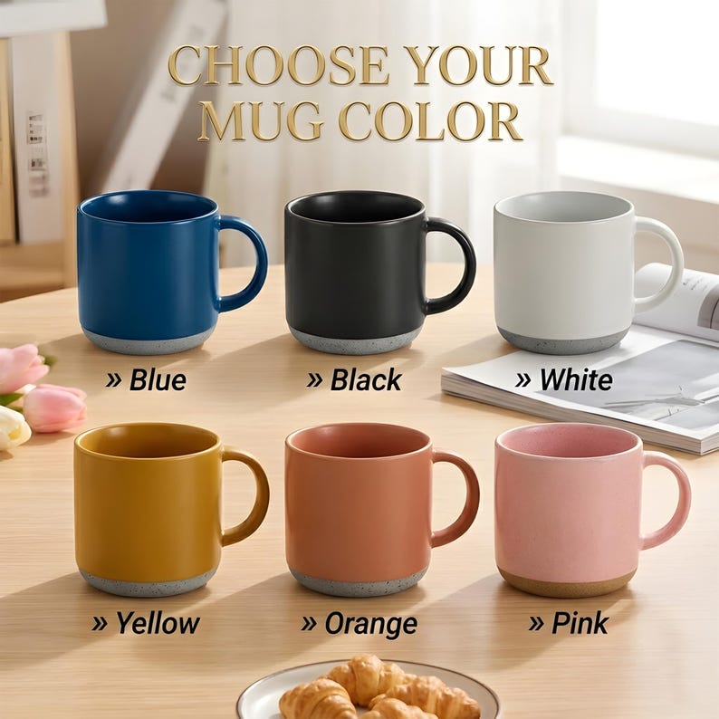 May include: Six ceramic mugs arranged in two rows with the text CHOOSE YOUR MUG COLOR at the top. The mugs come in blue, black, white, yellow, orange, and pink, each featuring a speckled gray base. Labels below each mug identify the specific color.