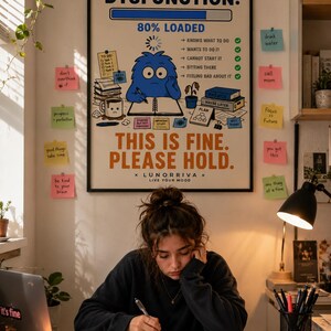 以下が含まれることがあります： Executive Dysfunction: 80% Loadedというタイトルの額入りウォールポスター。デスクでタスクリスト、コーヒーマグ、読み込みバーを前にした青いキャラクターが描かれている。テキストにはThis is fine. Please hold.およびLunorriva Live Your Moodと記されている。