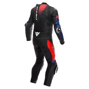 Puede incluir: Traje de carreras de moto negro y rojo con detalles azules. El traje muestra el nombre de la marca "DAINESE" en blanco en la espalda y la parte superior del brazo. Tiene protecciones en hombros, codos y rodillas.
