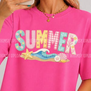 May include: A bright pink t-shirt with the word "SUMMER" in colorful, beach-themed lettering. The design includes a starfish, seashells, and waves, evoking a sunny, seaside vibe. The shirt is a casual, short-sleeved style.