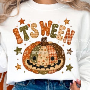 Può includere: Una felpa bianca con la grafica di una zucca in stile patchwork con un volto sorridente. Il testo "IT'S WEEN" appare sopra la zucca in un carattere a motivi vari. Piccole stelle e segni più circondano il design centrale della zucca.