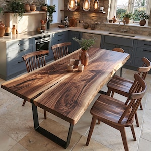 Op de afbeelding: Een eettafel van notenhout met een natuurlijke boomstamrand, een opvallende houtnerf en een donkere afwerking, ondersteund door zwarte U-vormige metalen poten. De tafel is omringd door zes bijpassende houten stoelen met spijlenrug.