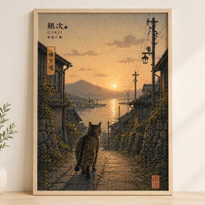 May include: A framed print showing a cat walking down a cobbled path towards a sunset over water. The print features Japanese text in the upper left and a red seal in the lower right. The scene is a traditional Japanese landscape with a warm colour palette.