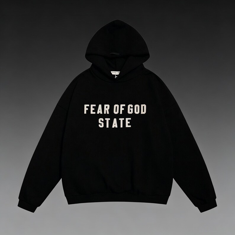 May include: Black hooded sweatshirt with the text "FEAR OF GOD STATE" in white block letters. The sweatshirt has a drawstring hood and a kangaroo pocket. The garment is made of a soft, comfortable material.