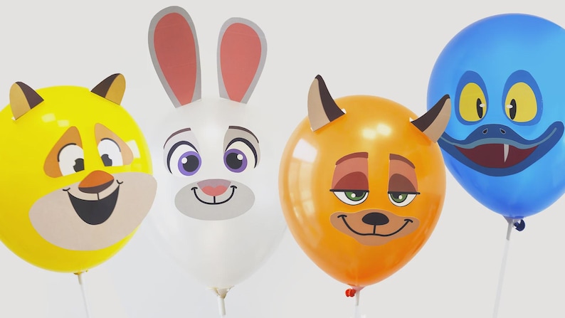 May include: Four colorful balloons with animal faces: a yellow cat, a white rabbit, an orange fox, and a blue monster. Each balloon has a unique, cartoonish design with smiling faces and large eyes. The balloons are on white sticks.