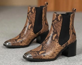 Botines Chelsea de piel de serpiente marrón, botines con tacón de bloque y puntera plateada.