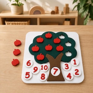 May include: A wooden educational counting board featuring a dark green tree with a brown trunk on a white square base. The tree has red apple-shaped pieces and empty slots. Ten white circular discs with red numbers 1 through 10 are included.